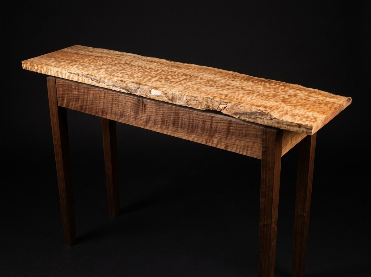 Brother hall table — floating quilted maple top on curly walnut base, on studio black.