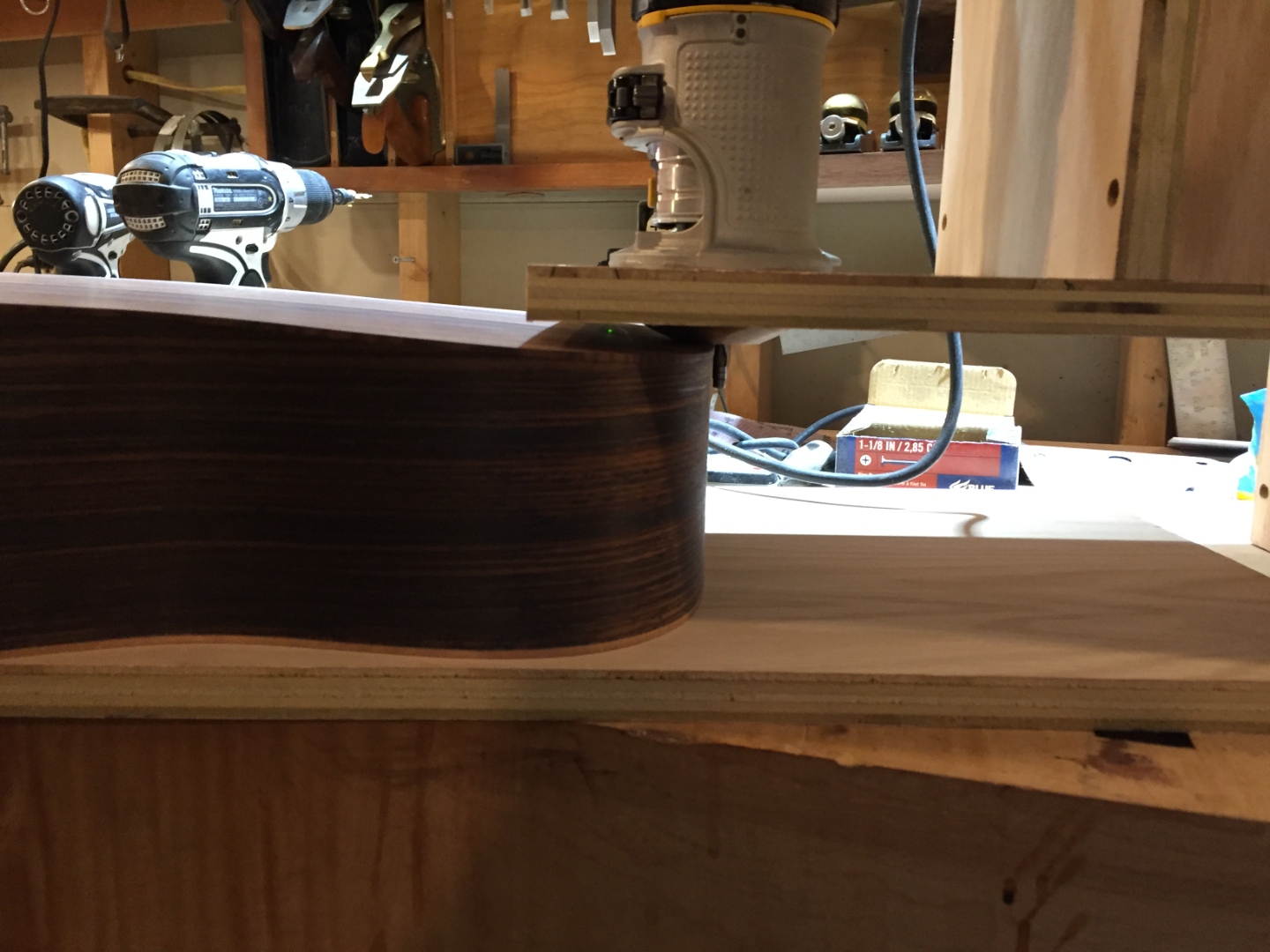 Side profile of a guitar body being routed for the binding channel.