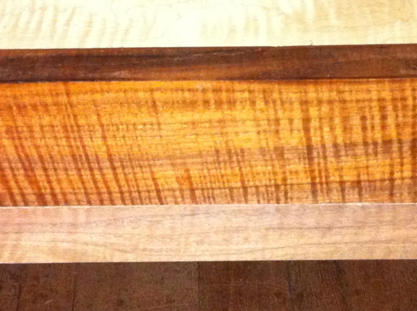 Strip layout of curly maple, curly walnut, and lighter maple for a laminated top.
