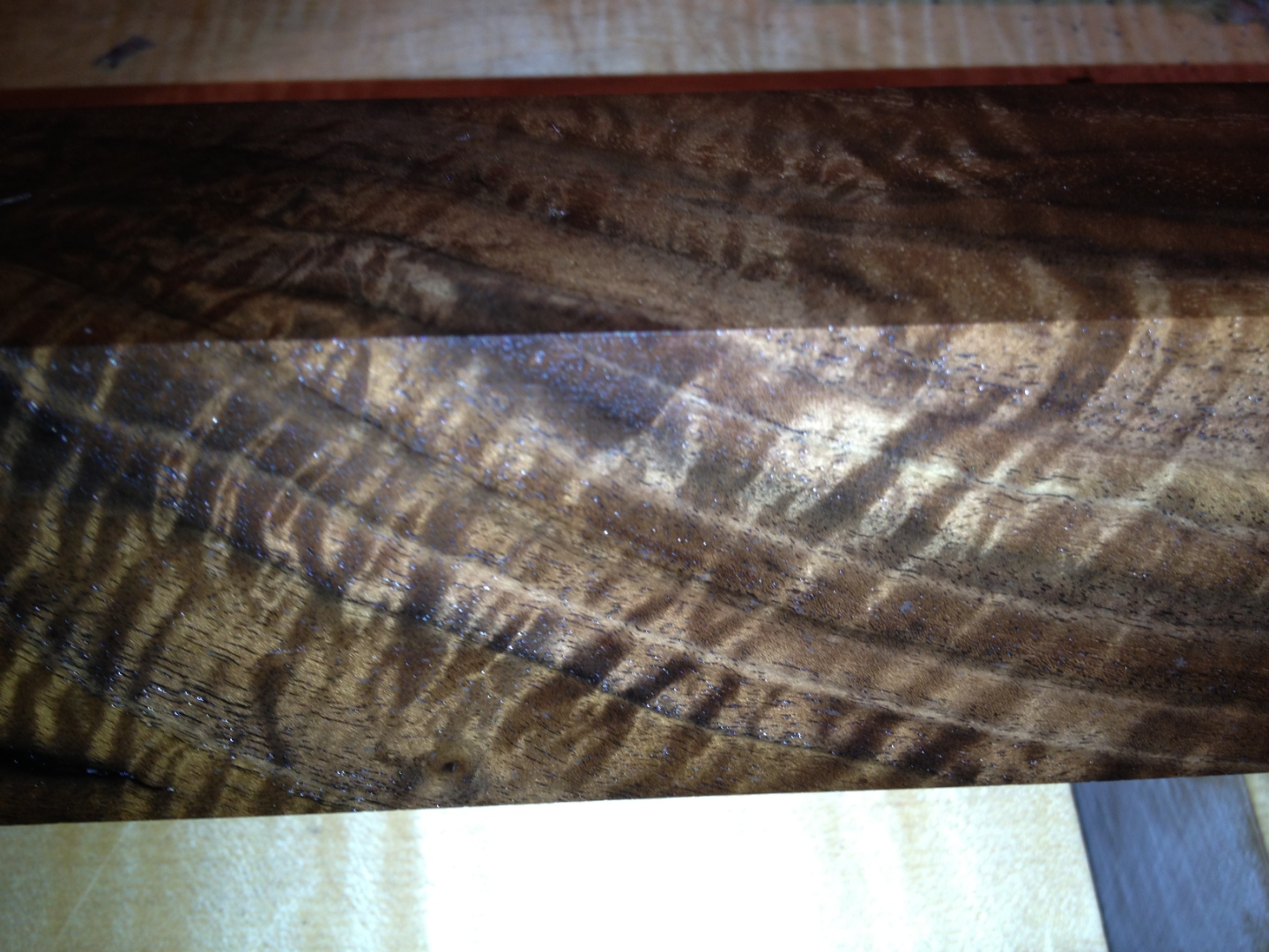 Curly walnut bookmatched detail, ribbon figure mirrored across the joint.
