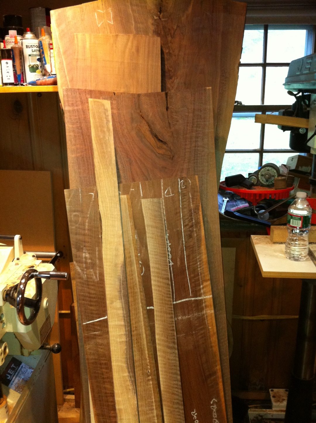Stack of walnut and figured stock leaning against a shop window.